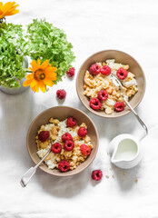 Delicious breakfast - cottage cheese with greek yogurt, raspberries and sugar cookies crumbs on a light background with flowers, top view