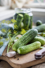 Pickling cucumbers .  Gucumbers , glass jar , garlic ,dill, currant leaves on a wooden table. Russian Traditional food .  pickled cucumbers . Recipes .