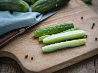 Sliced and whole cucumbers .  Cucumber on a cutting board .  Vegetables salad. Dieting. Vegetarian food.   