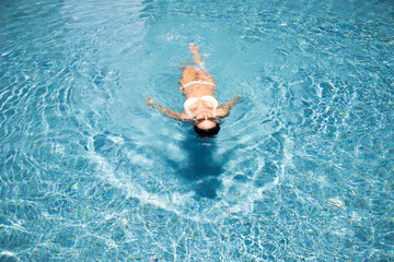 asian woman relax on water pool in summer happy sunbath
