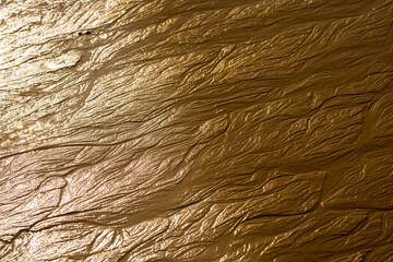 background of wet beach sand at sunset with curious and abstract shapes