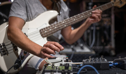 Fototapeta premium Guitar player on a stage with set of distortion effect pedals.