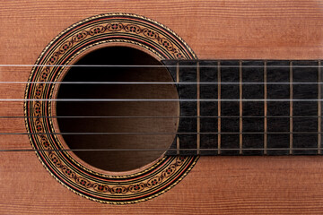 Close-up of old acoustic guitar showing detail of decorative rosette decal around soundhole,...
