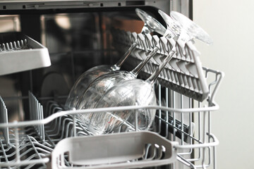 close up photo of raw wine glasses in a dishwasher. Cleaning concept.Selective focus for cleaning Wine glasses in dishwasher machine.