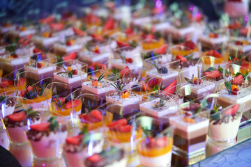 Obraz premium Beautiful and bright desserts on the festive table for the party. Confectionery with cream