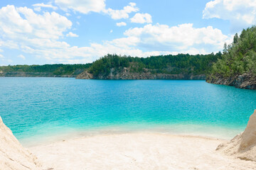 Fototapeta na wymiar Clean white sandy beach of a beautiful blue forest lake. Summer, noon, vacation