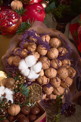 Gift for Christmas, a set-bouquet of walnuts, chocolate, cones and pomegranates