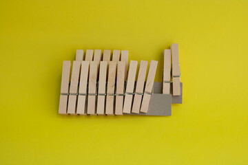 A set of wooden clothespins for drying clothes on a yellow background