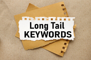 Long Tail Keywords, white torn paper on brown torn paper background. craft background