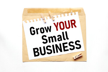 Grow Your Small Business. text on paper on craft envelope on white background