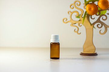 A bottle without a label with tangerine oil. Transparent glass bottle of brown color. A natural cosmetic product. Product banner. A place for text and design.