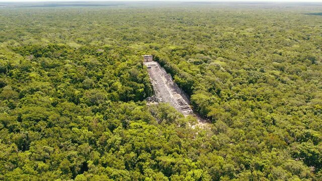 Aerial view of Ancient Mayan pyramid and Coba ruins in Mexico. Landscape panorama of Quintana Roo Peninsula from aboveL. Lush jungle on a sunny day, 4k UHD.