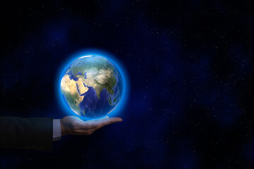 A businessman hand wear suit with earth sphere and map over his hand in the dark background. World global business and environment concept.