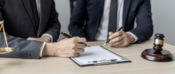 Two male lawyers are consulting together to draft a contract acknowledgment for their clients, they form partnerships to open a law firm. The idea of opening a law firm to accept the lawsuit.