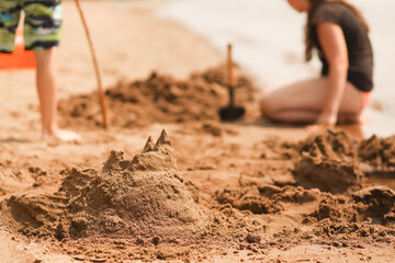 Children build a sand castle on the beach