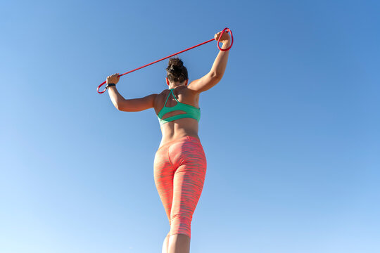 woman exercising outdoors with rubber bands