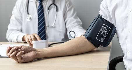 The doctor is checking the blood pressure and listening to the patient's pulse. The concept of annual physical examination for healthy health care and timely disease detection and treatment.