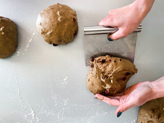 Baker cooks custard rye bread with cranberries on a gray work surface