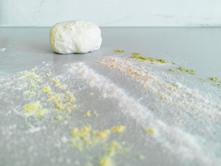 A piece of dough and four types of different flour on the table