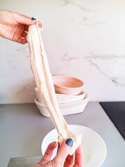 The baker checks a piece of dough for elasticity before kneading