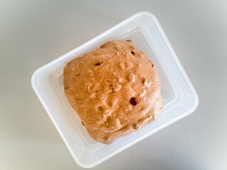 Plastic container with rye custard douhgh with cranberry