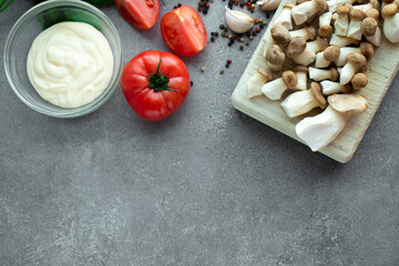 Little mushrooms, tomatoes, sus and spices on a gray background