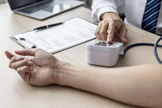 The Doctor Is Checking The Blood Pressure And Listening To The Patient's Pulse. The Concept Of Annual Physical Examination For Healthy Health Care And Timely Disease Detection And Treatment.