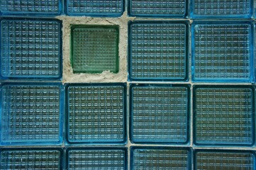 Background of one green and many blue glass squares
