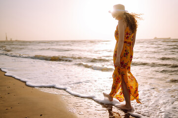 Fototapeta na wymiar Young happy woman walks along seashore. Travel, weekend, relax and lifestyle concept.