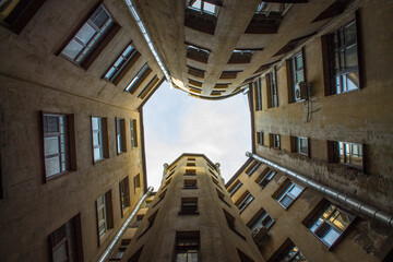 Traditional courtyard-well in St. Petersburg Russia with closed high walls and a view of the sky from below