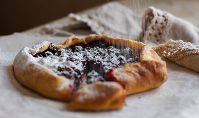The pie is sprinkled with powder. Сurrant pie. Powdered sugar. Biscuit with currants. Tart with currants