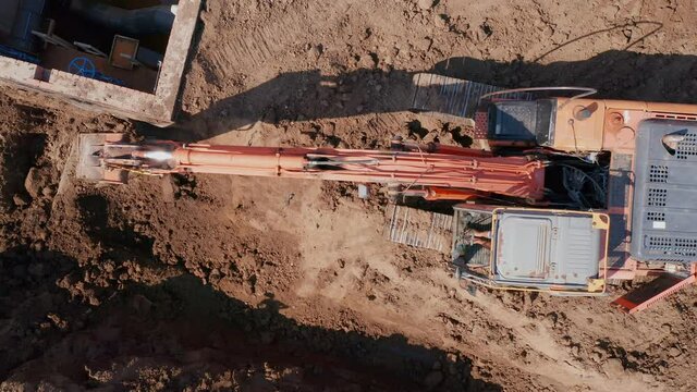 Mechanization of construction works. A full-rotary excavator digs a rectangular foundation pit. Construction industry. Aerial photography. High quality. 4k footage.
