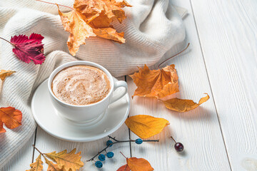 A cup of coffee and a sweater on an autumn background. Side view, space for copying.