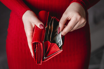 Red wallet in the hands of woman in a red dress with red manicure - obrazy, fototapety, plakaty