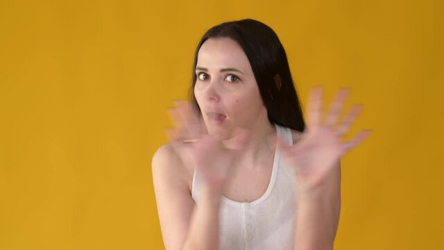 Portrait young caucasian woman shaking his head showing NO gesture isolated on yellow studio background. People emotions lifestyle concept.