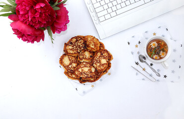 Modern woman's desktop, home office, flower tea and pancakes on a light table. Healthy breakfast with ingredients, healthy lifestyle concept, flat lay,