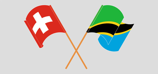 Crossed and waving flags of Switzerland and Tanzania