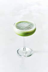 Smoothie and refreshing summer shake Iced Matcha Latte served in Champagne Saucer glass on white background