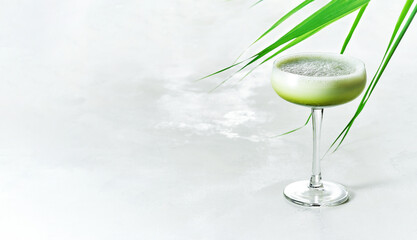 Creamy smoothie and refreshing summer shake Iced Matcha Latte served in Champagne Saucer glass on white background