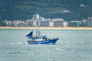 Fishing and pleasure boats sailing along the coast of the city of Laredo in the province of...