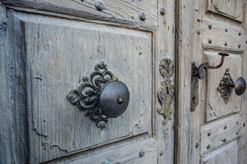 Close-up of an old wooden door with beautiful metal door handles.