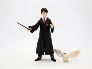 Obraz premium Harry Potter with his white owl Hedwig. Harry dressed in his Hogwarts School of Witchcraft and Wizardry uniform and his wand in hand. Collectible toy for children. Character from the J. K. Rowling.