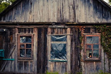Facade with windows of a very old dilapidated wooden house