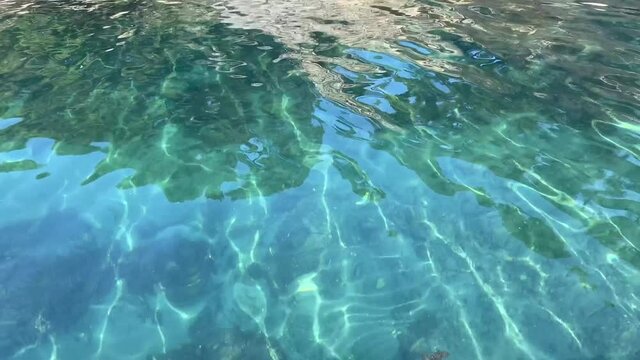Sea blue transparent sea surface at summer. Shiny clear ocean. Turquoise glittering aqua in paradise lagoon.