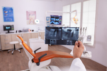 Orthodontist radiologist analyzing teeth jaw radiography working at healthcare treatment in stomatology orthodontic hospital office room. Doctor examining surgery dentistry expertise