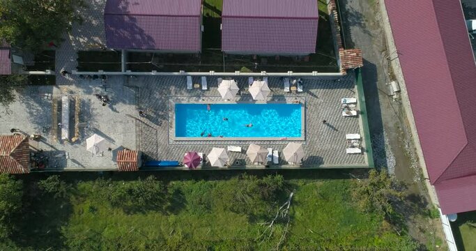 Aerial Swimming pool full of people having fun, view from above. Up flying shot 