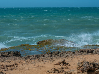 White Spume Known as Sea, Ocean or Beach Foam Created by the Agitation of Seawater over the Rocks of the Shore