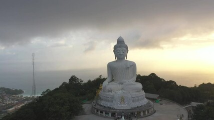 aerial panorama view scenery yellow sun with rain clouds moving..beautiful Phuket big Buddha on the top of mountain.. Another incentive to attract tourists to visit. popular landmark of Phuket