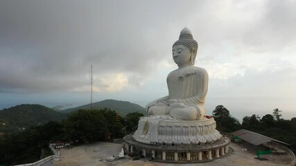 aerial panorama view scenery yellow sun with rain clouds moving..beautiful Phuket big Buddha on the top of mountain.. Another incentive to attract tourists to visit. popular landmark of Phuket