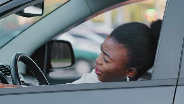 Afro american stressed woman driver african ethnic girl sitting inside luxury car screaming angry waving hands make stop after driving automobile in traffic jam on rush hour, travel and transportation